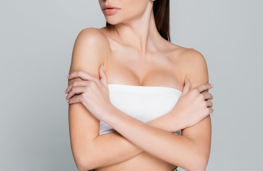 Image pretty young woman with bare shoulders and makeup looking away isolated on grey